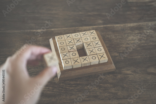 ox tic-tac-toe game made by wood block on wooden table. education & leisure concept. risk, strategy, competiton in business photo