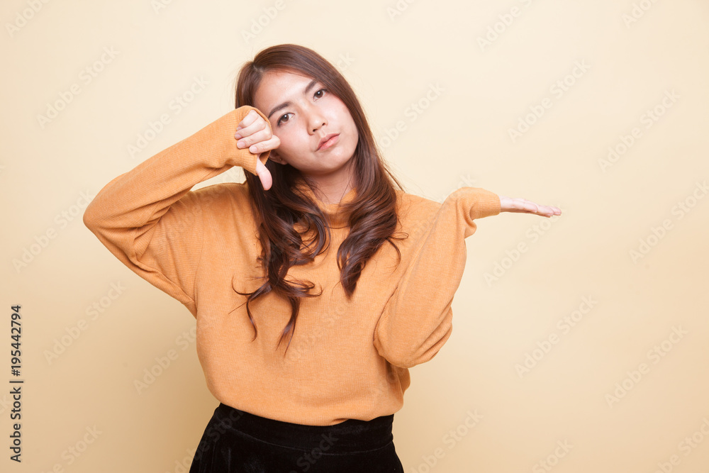 Fototapeta premium Young Asian woman show palm hand and thumbs down.