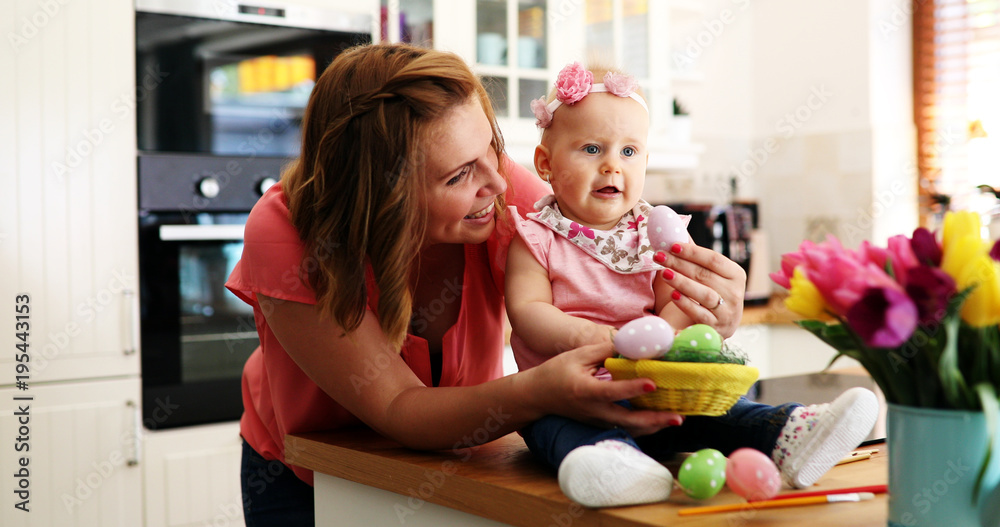 Mother and her baby painting easter eggs