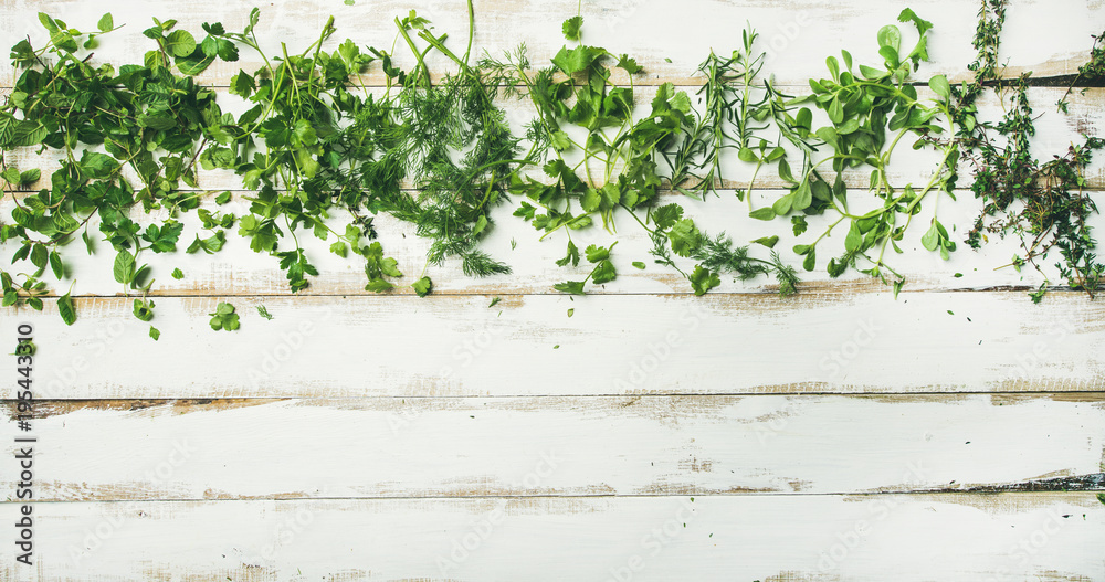 Flat-lay of various fresh green herbs. Parsley, mint, dill, cilantro, rosemary, thyme over rustic white wooden background, top view, copy space. Healthy vegan cooking concept - obrazy, fototapety, plakaty 