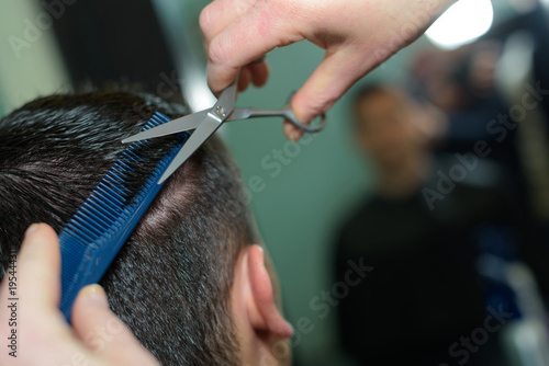 close-up of hairdresser cutting hair of a male