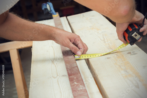 Carpenter working on the raw board / wood.