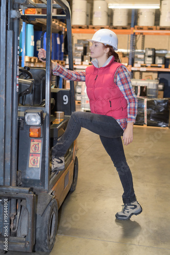 Woman stepping up into fork lift truck