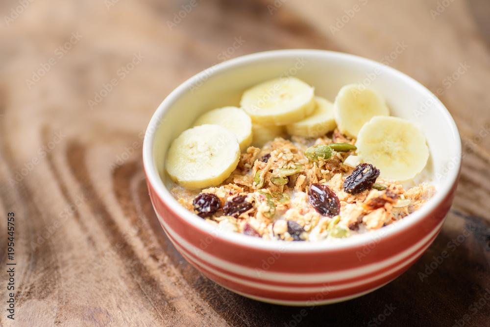 Healthy breakfast, muesli with cereal, slice banana and milk in a bowl Healthy breakfast, muesli with cereal, slice banana and milk in a bowl