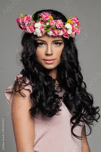 Beautiful Young Woman with Make up, Long Healthy Curly Hair and Flowers on her Head