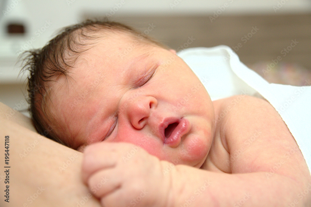 A newborn baby sleeps on his dad's chest A newborn baby sleeps on his dad's chest
