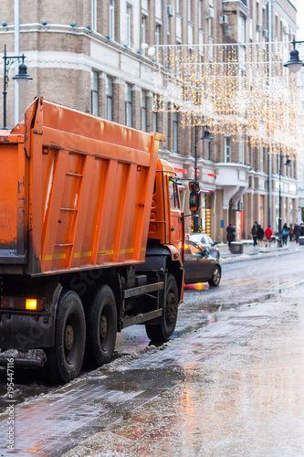 Municipal cleaning service workers remove waste with a garbage truck