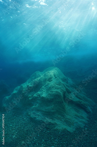 A rock underwater on the seabed with natural sunlight below water surface, Mediterranean sea, Costa Brava, Catalonia, Spain