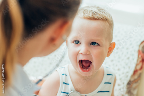 Little boy opening mouth during examination photo