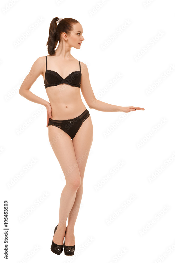 Young cute woman in black lingerie standing on white background. Stretched arm at waist level Young cute woman in black lingerie standing on white background. Stretched arm at waist level
