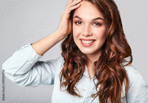 Portrait of young stylish laughing girl model in colorful casual summer clothes with natural makeup isolated on gray background. Looking at camera