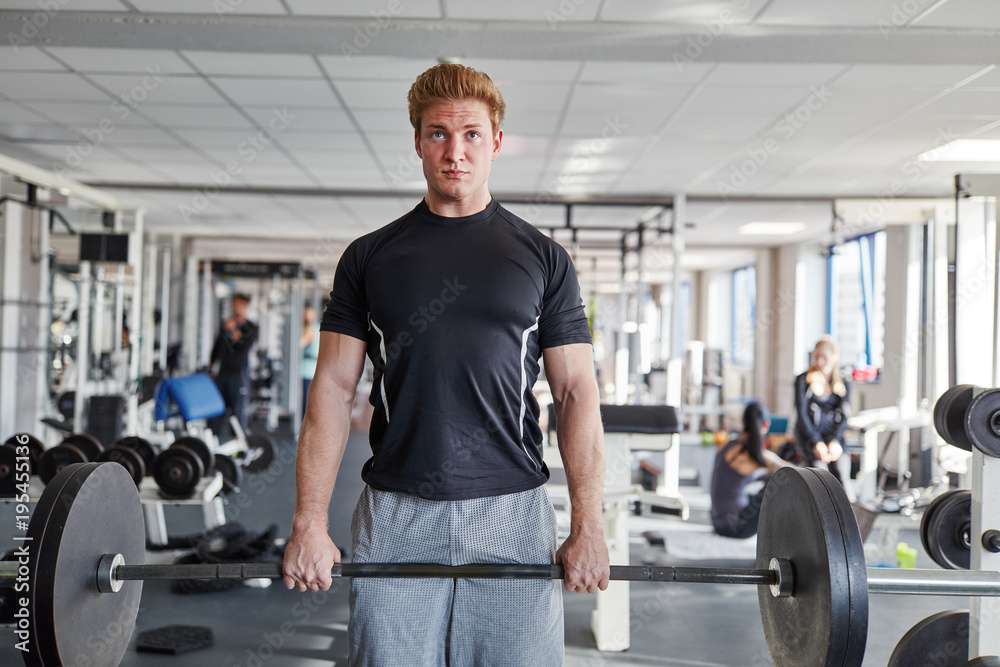 Young man doing exercise with barbell in the gym Young man doing exercise with barbell in the gym