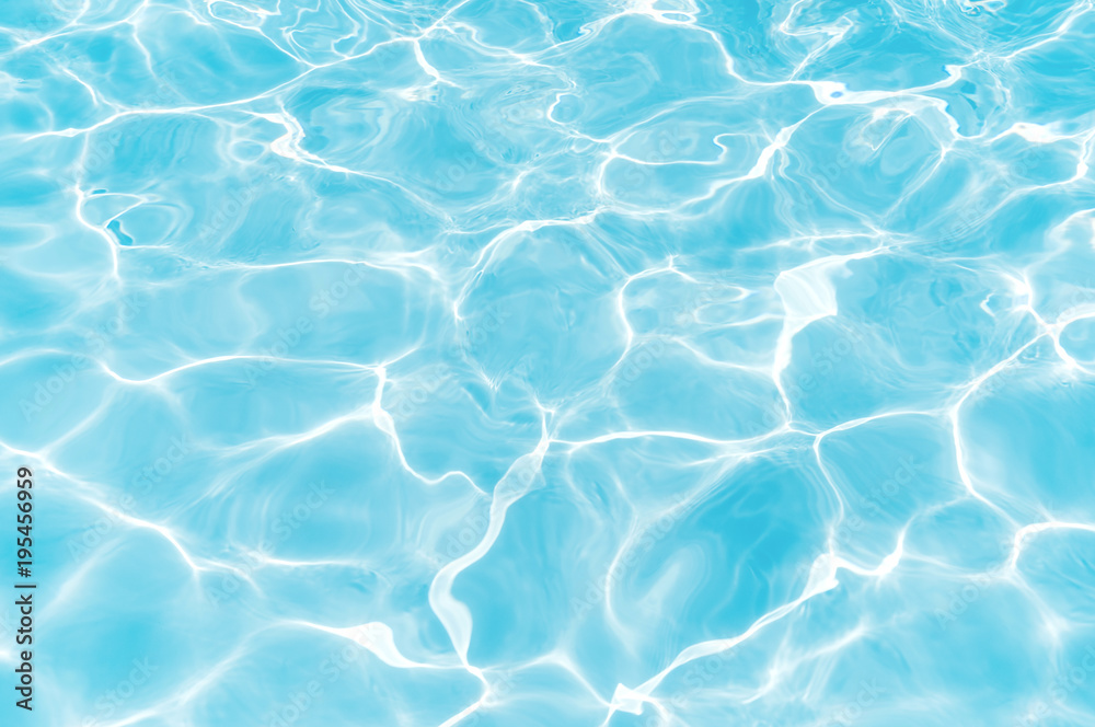 Blue and bright water surface with sunrefection in swimming pool for background