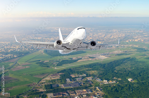 Airplane is climb flight level high view in the air, against the background sky horizon the airport of the runway, city, fields, forests and roads. photo