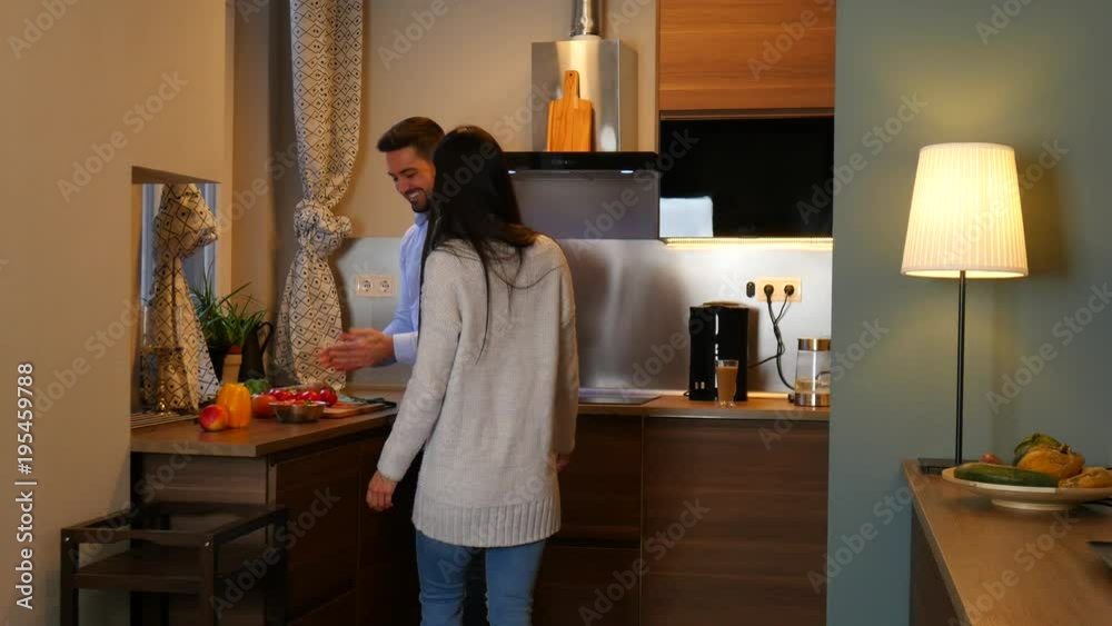 A young couple cooking together in the kitchen at home.
A young couple cooking together in the kitchen at home.