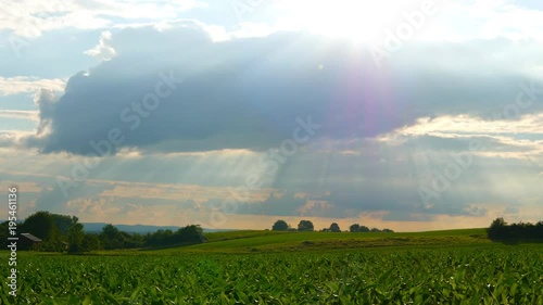 Sunshine breaking through clouds over a idyllic landscape	in Germany.
