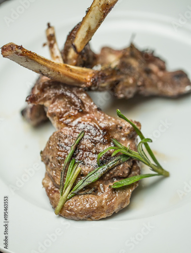 Fried lamb chops with vegetables on a white plate