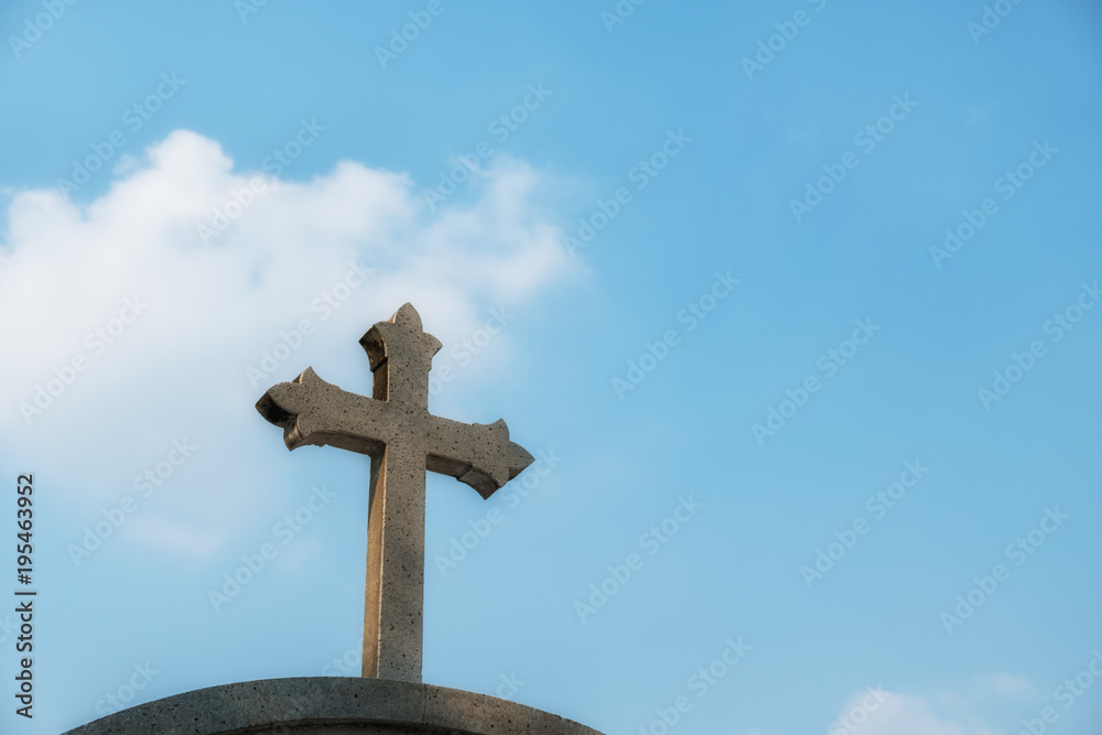 stone cross against blue sky. with copy space.