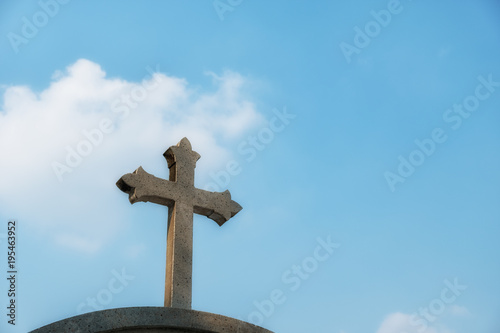 stone cross against blue sky. with copy space.