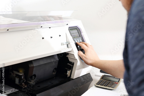 Maszyna drukarska. Pracownik obsługuje maszynę drukującą.