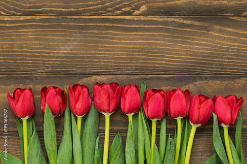 Row of tulips on wooden background with space for message. Mother s Day background. Top view