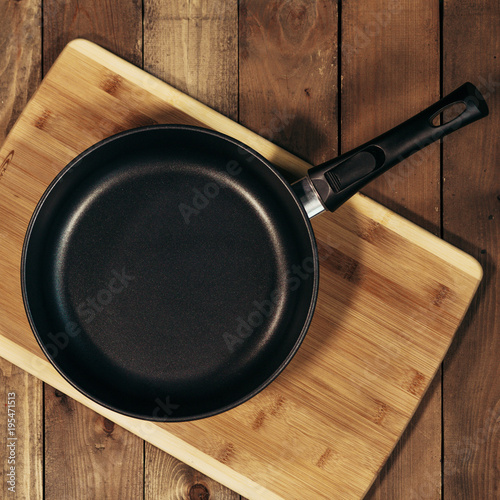 Empty frying pan on a wooden table, top view, rural style