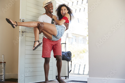 Man Carries Woman Over Threshold Of Honeymoon Rental photo