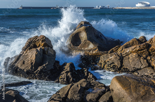 Waves of Atlantic Ocean crashing on rocks in Porto, Portugal photo