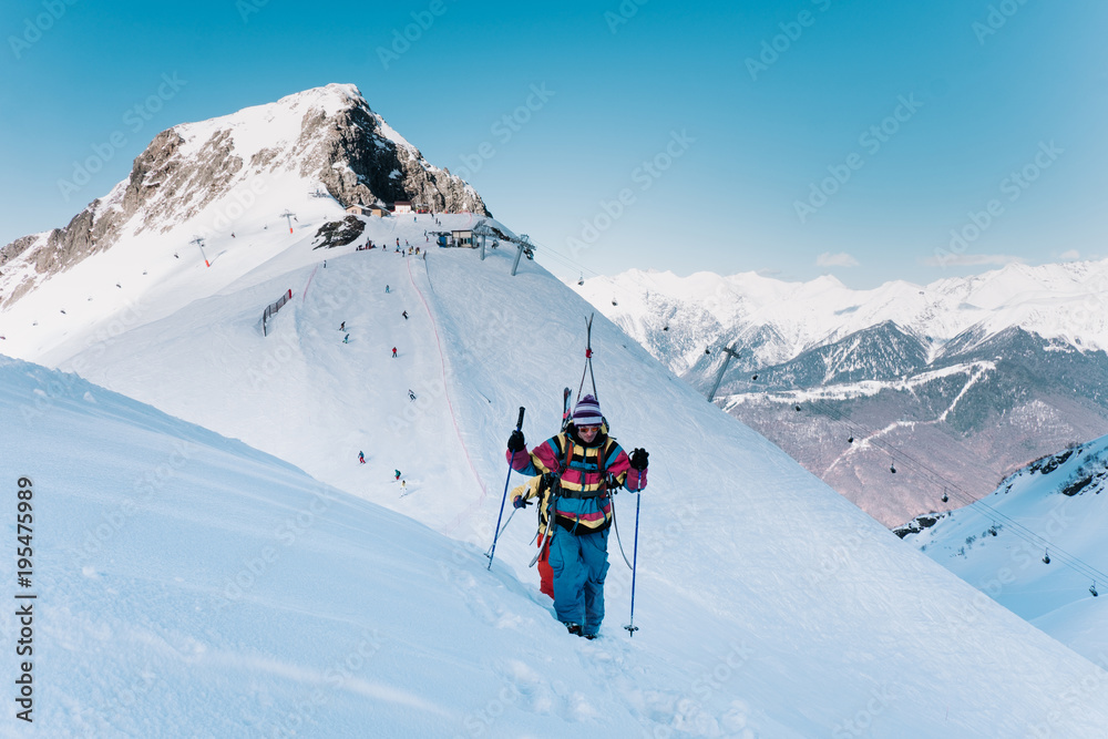 Skiers in ski suits climb the mountain, freeride.