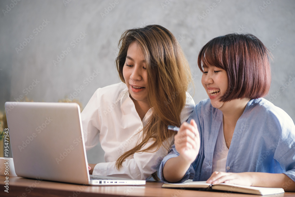 Two young business women sitting at table in cafe. Asian women using laptop and cup of coffee. Freelancer working in coffee shop. Working outside office lifestyle. One-on-one meeting. Two young business women sitting at table in cafe. Asian women using laptop and cup of coffee. Freelancer working in coffee shop. Working outside office lifestyle. One-on-one meeting.