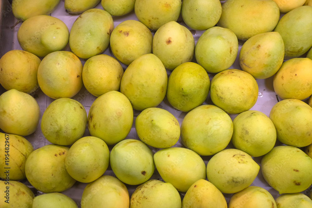 Fresh yellow raw manggoes display for sale at market