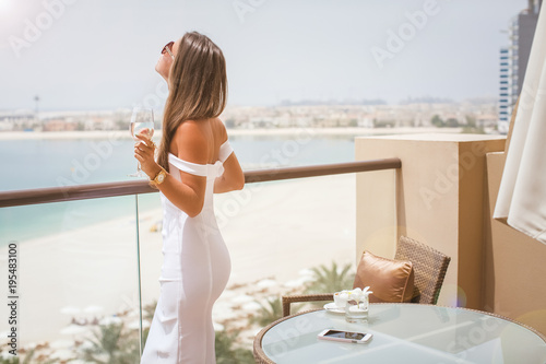 Photography Luxury travel vacation woman with champagne glass looking at view on Dubai