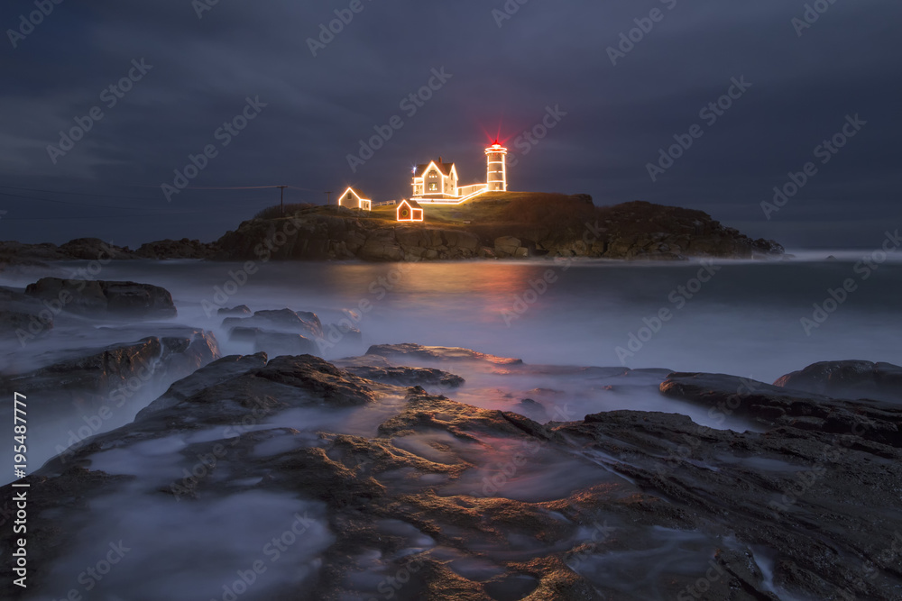 Holiday lights at Nubble Lighthouse in Maine during high tide