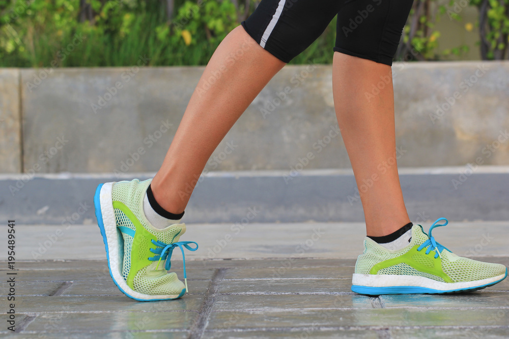 Closeup on shoe, Woman running on morning in the park, fitness and healthy lifestyle concept