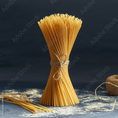 Uncooked pasta spaghetti on a blue background