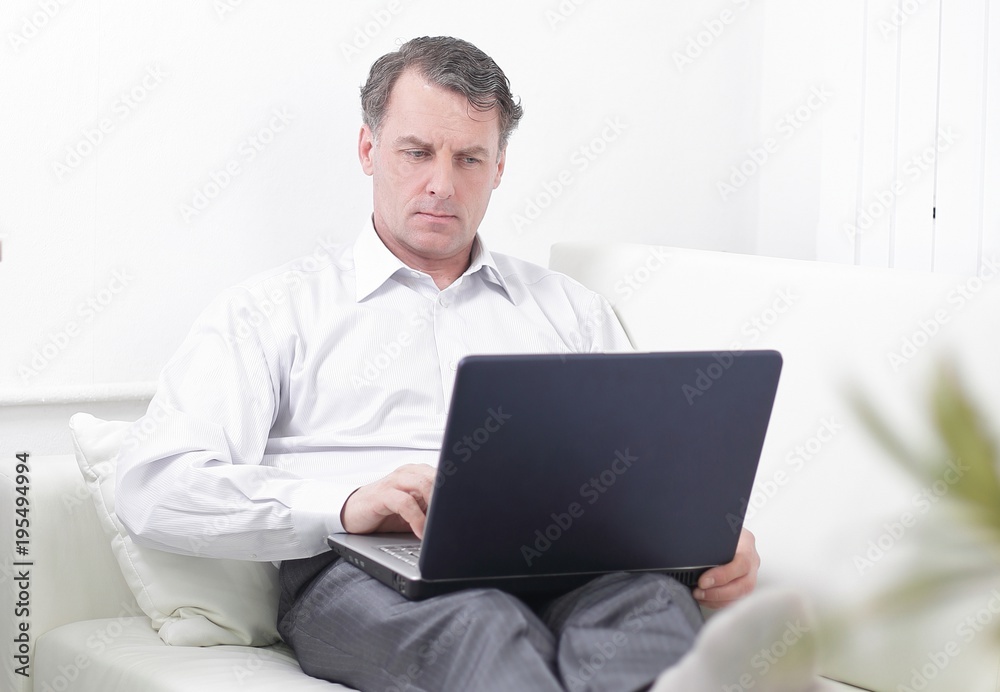 businessman working on laptop while sitting in a hotel room businessman working on laptop while sitting in a hotel room