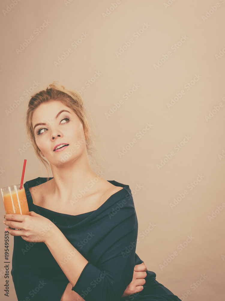 Thinking woman holding fresh orange juice Thinking woman holding fresh orange juice