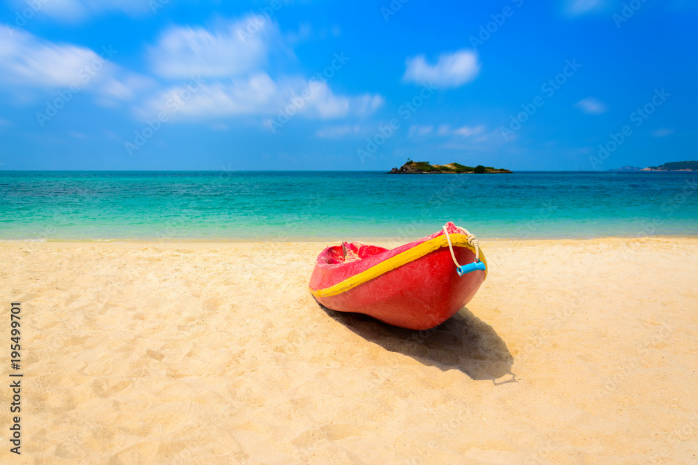 Red boat on the beach with blue sea and blue sky background
