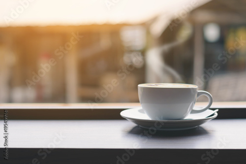 Coffee cup on the table and window background