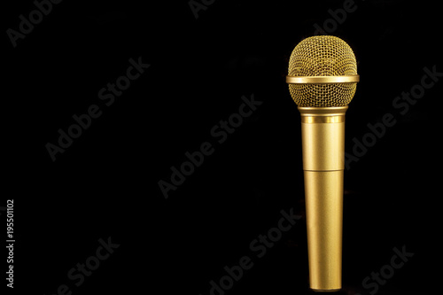 Golden microphone on black background.
