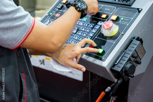 Mechanical technician operating program on control panel of high precision CNC machining center, machining die metal mold process