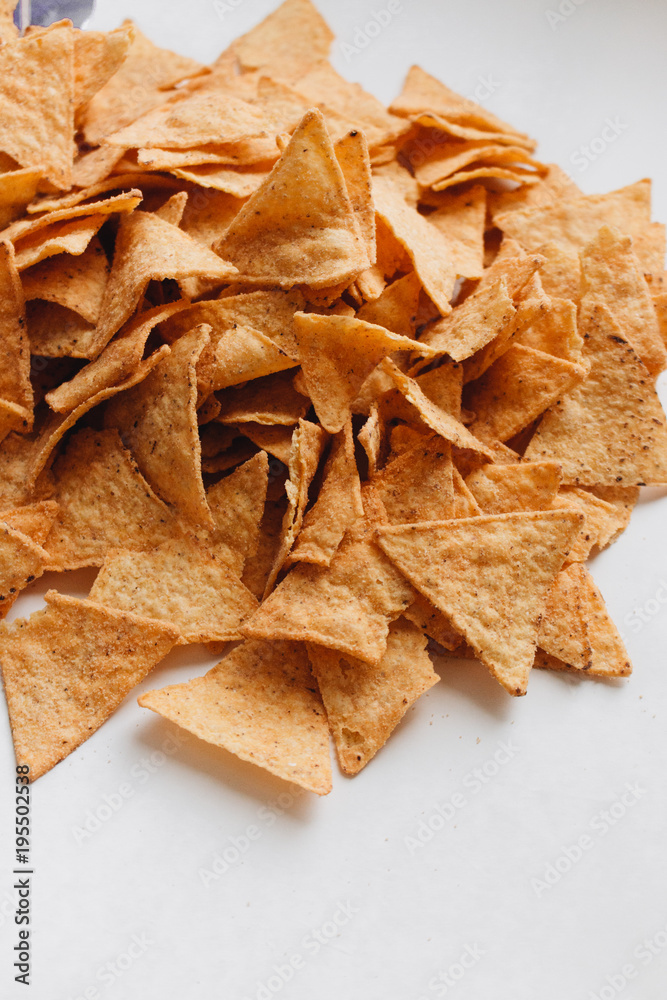 Pile of delicious crispy nachos of out pack on white background, traditional Mexican cuisine Pile of delicious crispy nachos of out pack on white background, traditional Mexican cuisine