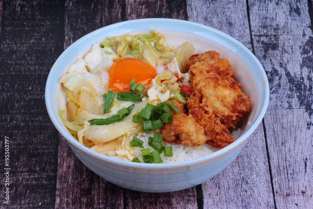 Jasmine rice with deep fried Chicken topped soft boil eggs and fried pork with mixed vegetablein Japanese style. Jasmine rice with deep fried Chicken topped soft boil eggs and fried pork with mixed vegetablein Japanese style.