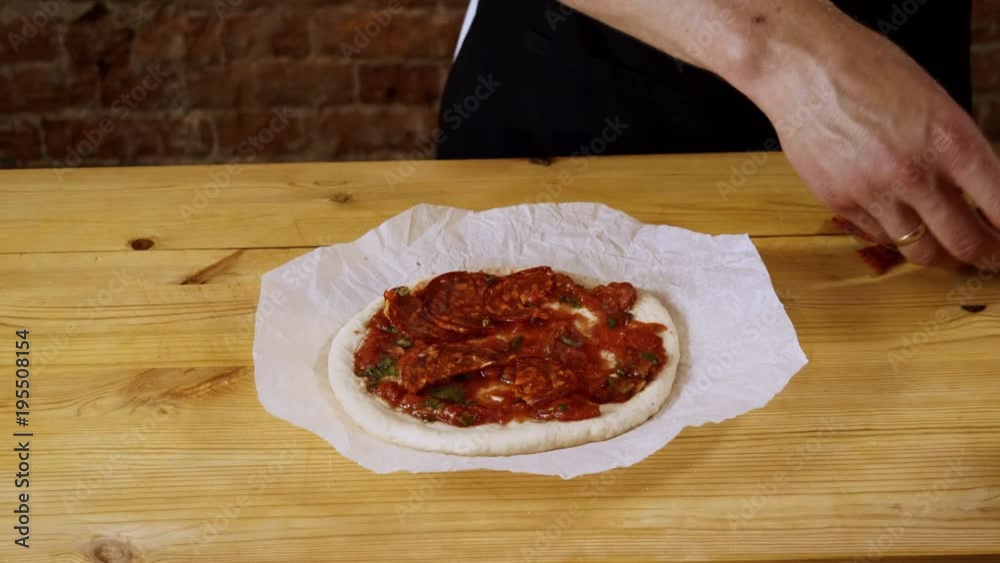 The cook adding slices of smoked sausage on pepperoni pizza. 4K The cook adding slices of smoked sausage on pepperoni pizza. 4K