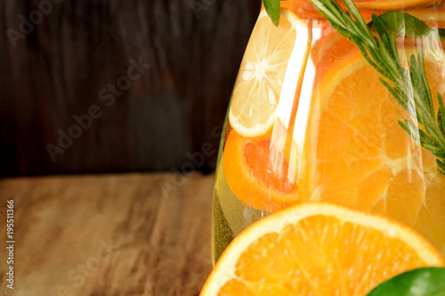 Foto Water with orange, lemon and mandarin slices in a glass jug