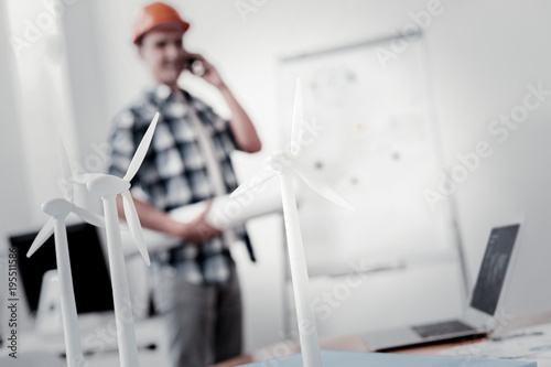 Busy builder. Focused photo on windmills model that standing on the table and being ready for presentation