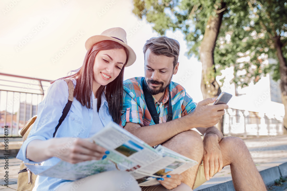 Tourist couple traveling and using map/Tourist couple exploring city. Tourist couple traveling and using map/Tourist couple exploring city.