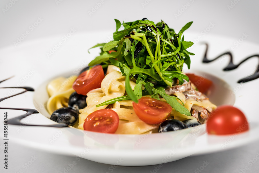 Pasta with vegetables on plate, traditional Italian food, pasta, tomatoes, rucola