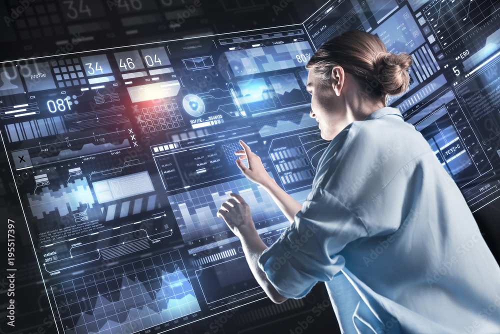Fototapeta premium Calm employee. Peaceful confident young programmer feeling calm while working with a futuristic device and smiling