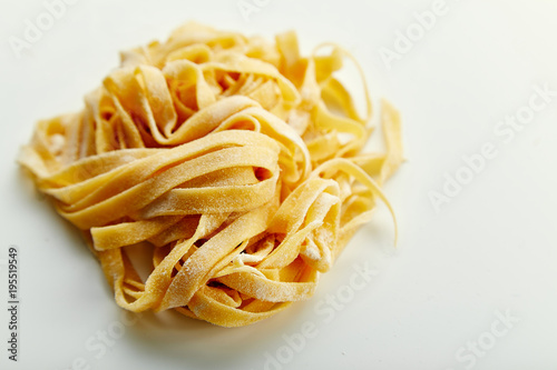 Handmade italian tagliatelle pasta on white background